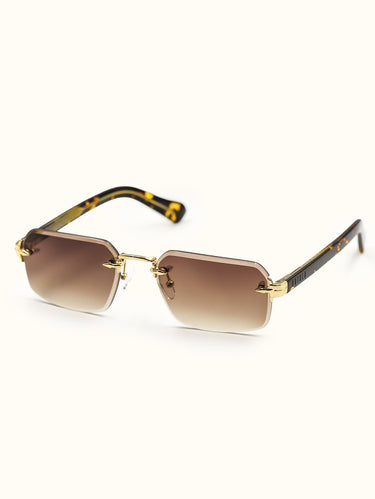 Sunglasses with gold frame and tortoiseshell arms on a white background